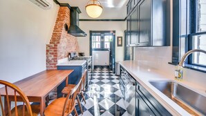 A kitchen with a black and white checkered floor, a brick oven, and modern cabinetry. - Radiant Gloucester House w/ Private Porch! (Gloucester)