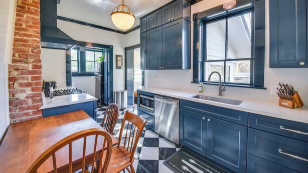 A kitchen with dark blue cabinets, a gas stove, a sink, and a window overlooking the backyard. - Radiant Gloucester House w/ Private Porch! (Gloucester)