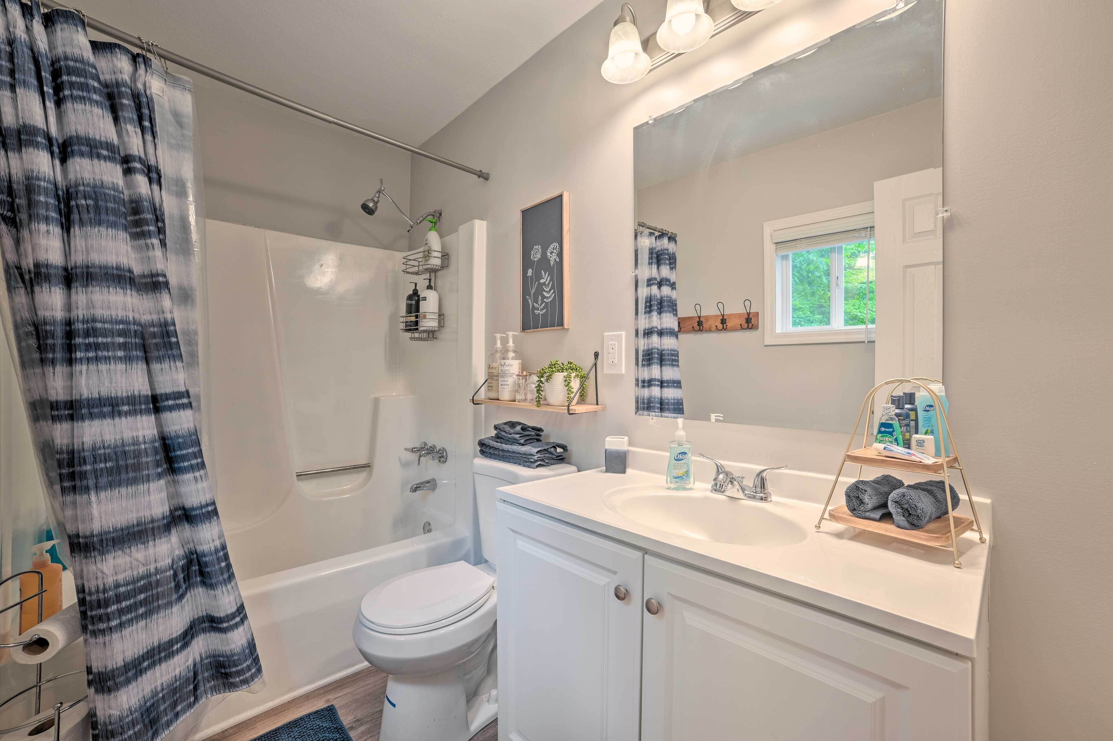 A bathroom with a white sink, a mirror, a towel rack, and a shower curtain.