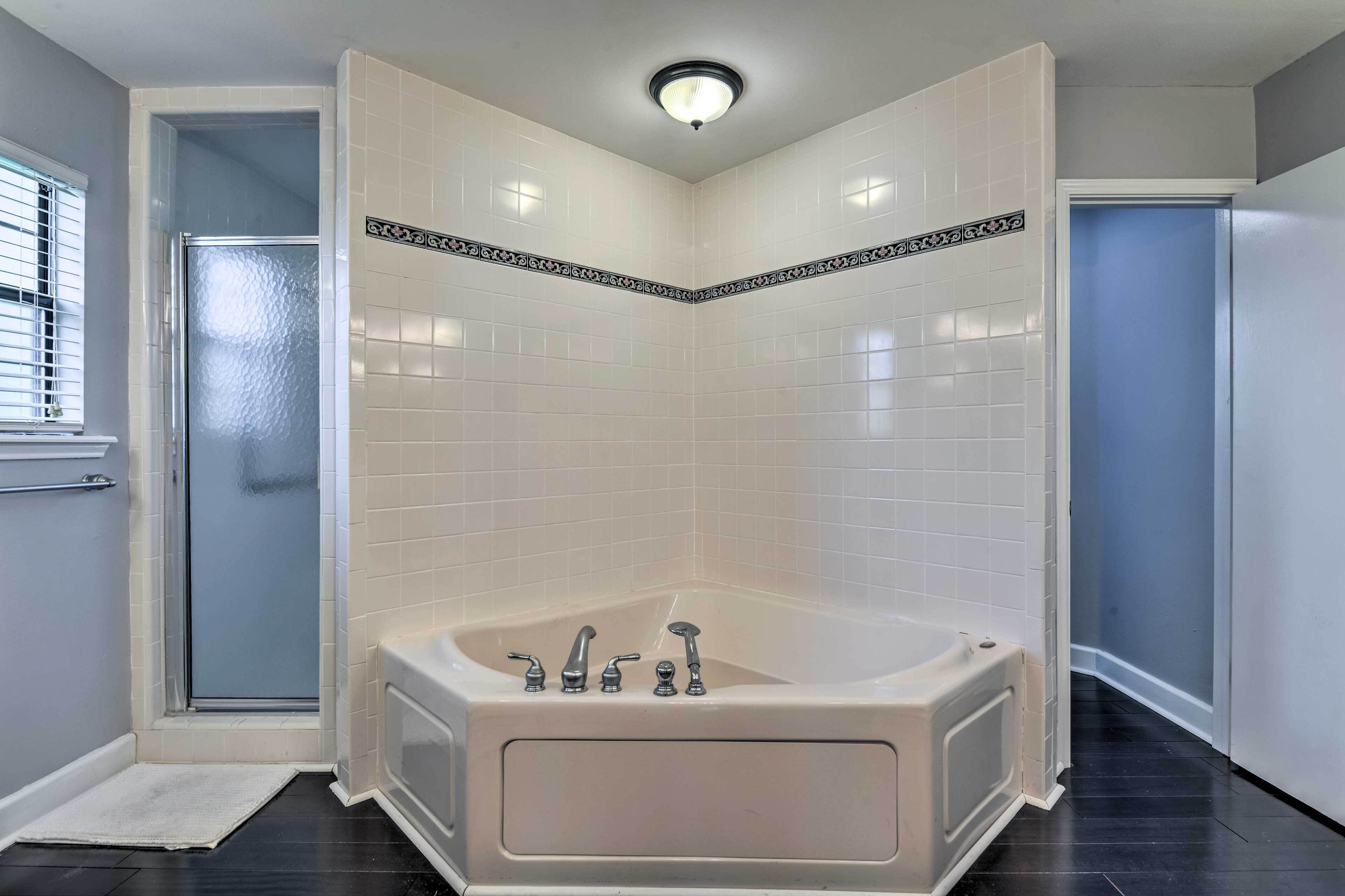 Une salle de bain d’angle avec une baignoire, une douche et des toilettes.