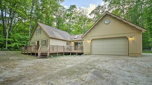A two-story house with a deck and a garage. - Higgins Lake Getaway - Boating, Fish, Golf, Atv! (Roscommon)