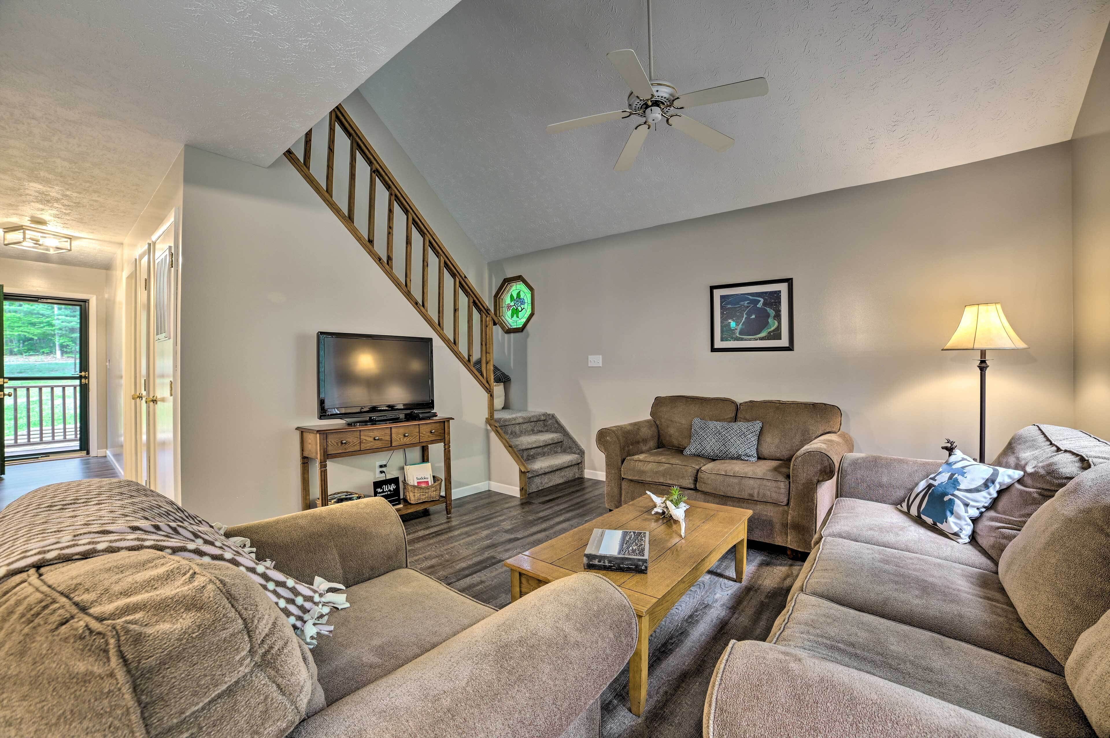 A living room with a staircase, a television, and a sofa.