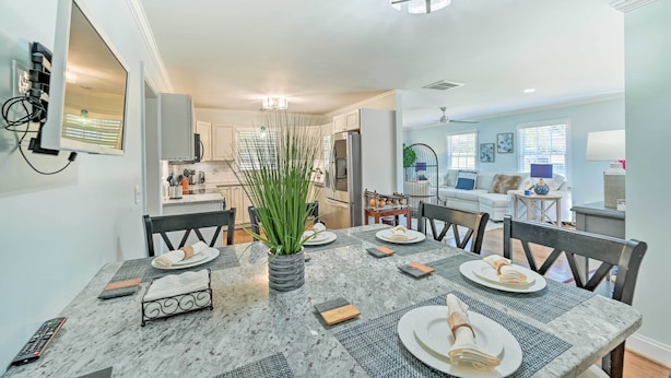 A dining area with a marble table, chairs, and a vase with green plants. - Ranch-style Home 7 Mi to Downtown Greensboro! (Greensboro)