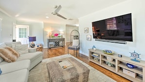 A living room with a sofa, coffee table, TV, and a fireplace. - Ranch-style Home 7 Mi to Downtown Greensboro! (Greensboro)