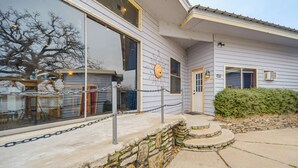Une maison avec un mur de soutènement en pierre, une terrasse en bois et une clôture en treillis métallique.