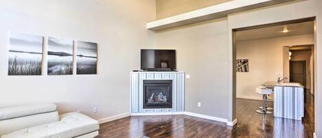 A modern living room with a fireplace, a sofa, and artwork on the wall.