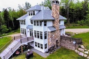 A large, multi-story house with a stone chimney, a covered porch, and a stone wall. - Secluded Home, 7 Mins to Stratton Mountain Resort (Bondville)