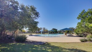 Un parque con piscina, mesas de picnic y zonas techadas.
