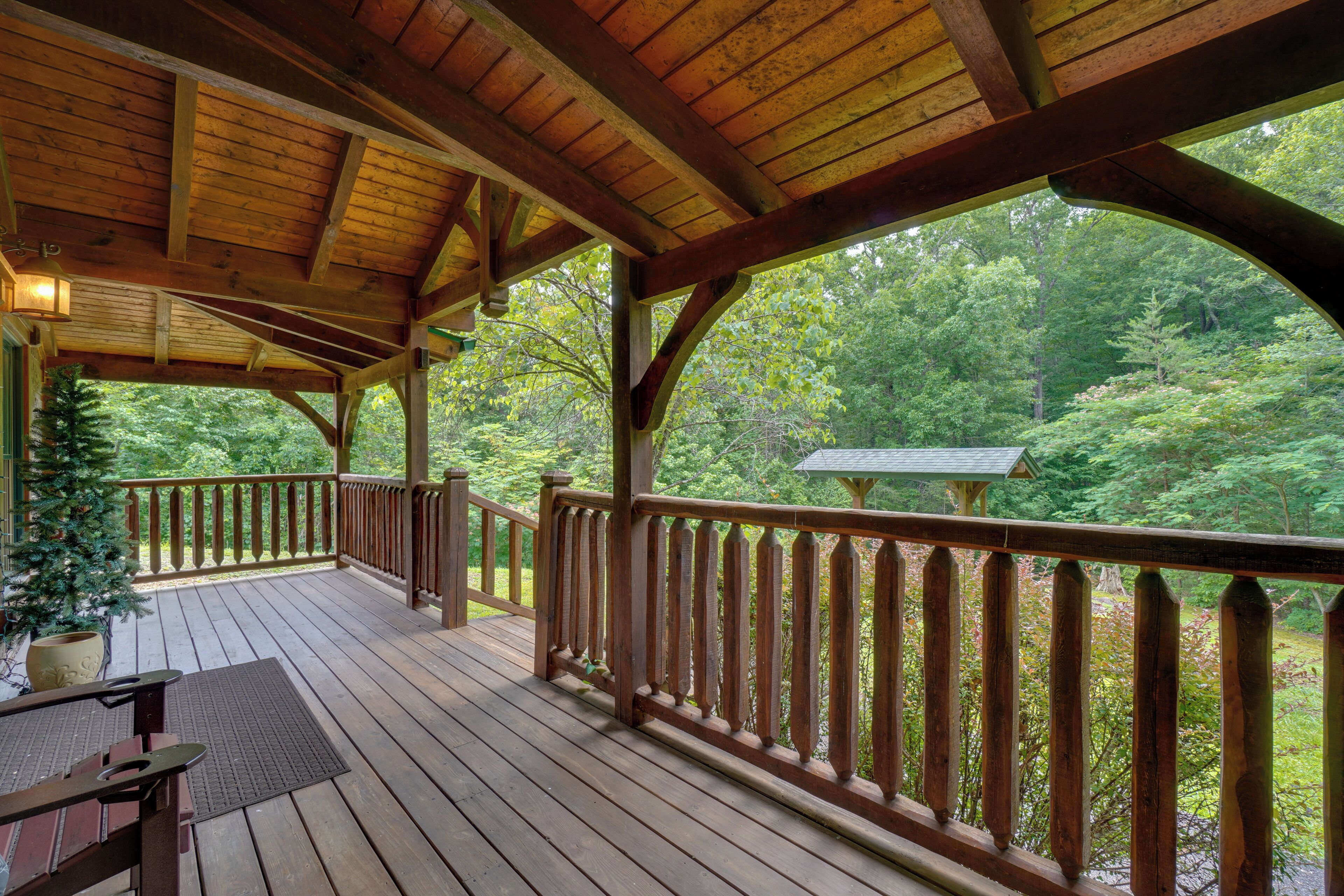 A wooden deck with a railing, a table, and a potted plant.