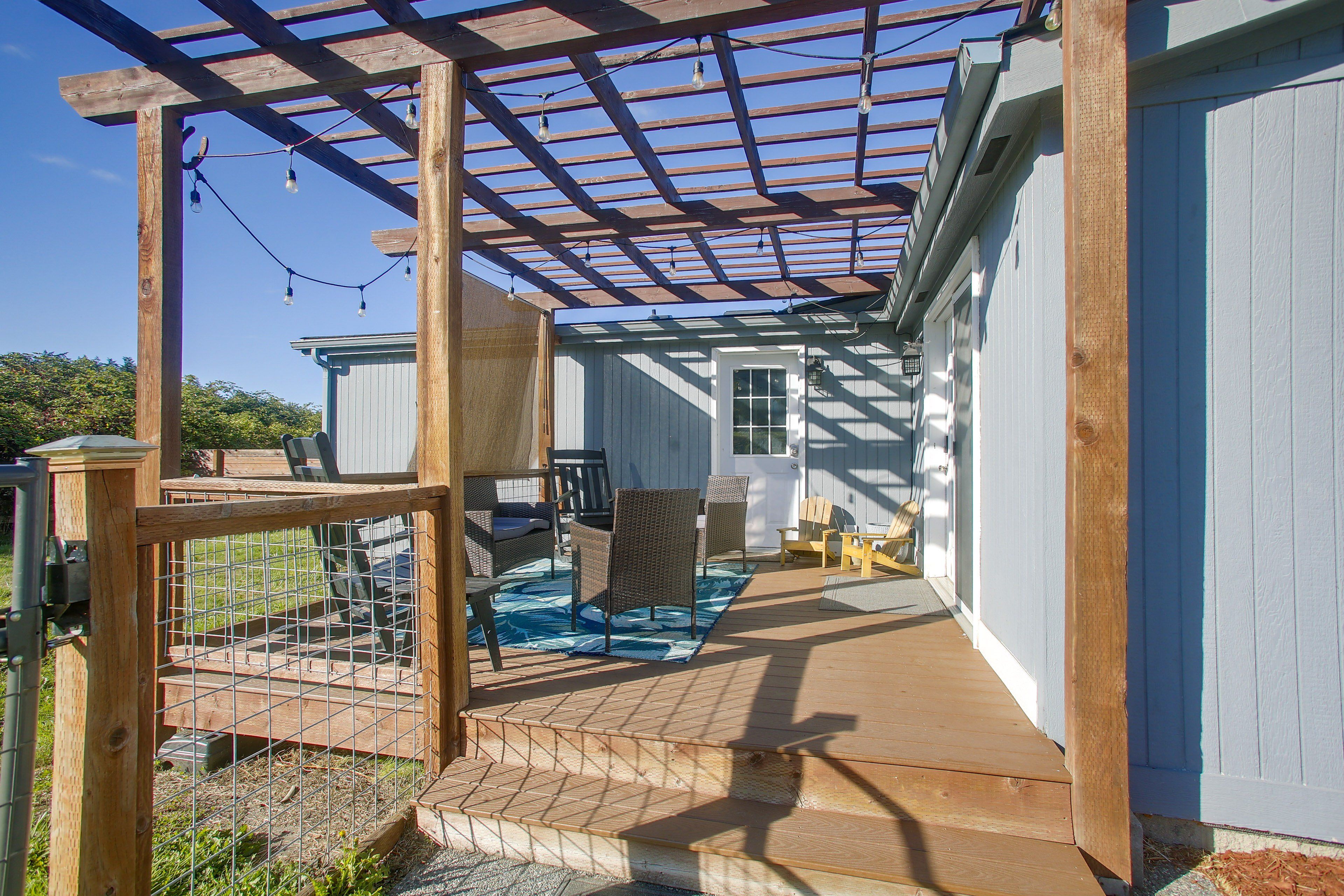 A covered outdoor area with a pool, wooden deck, and seating.