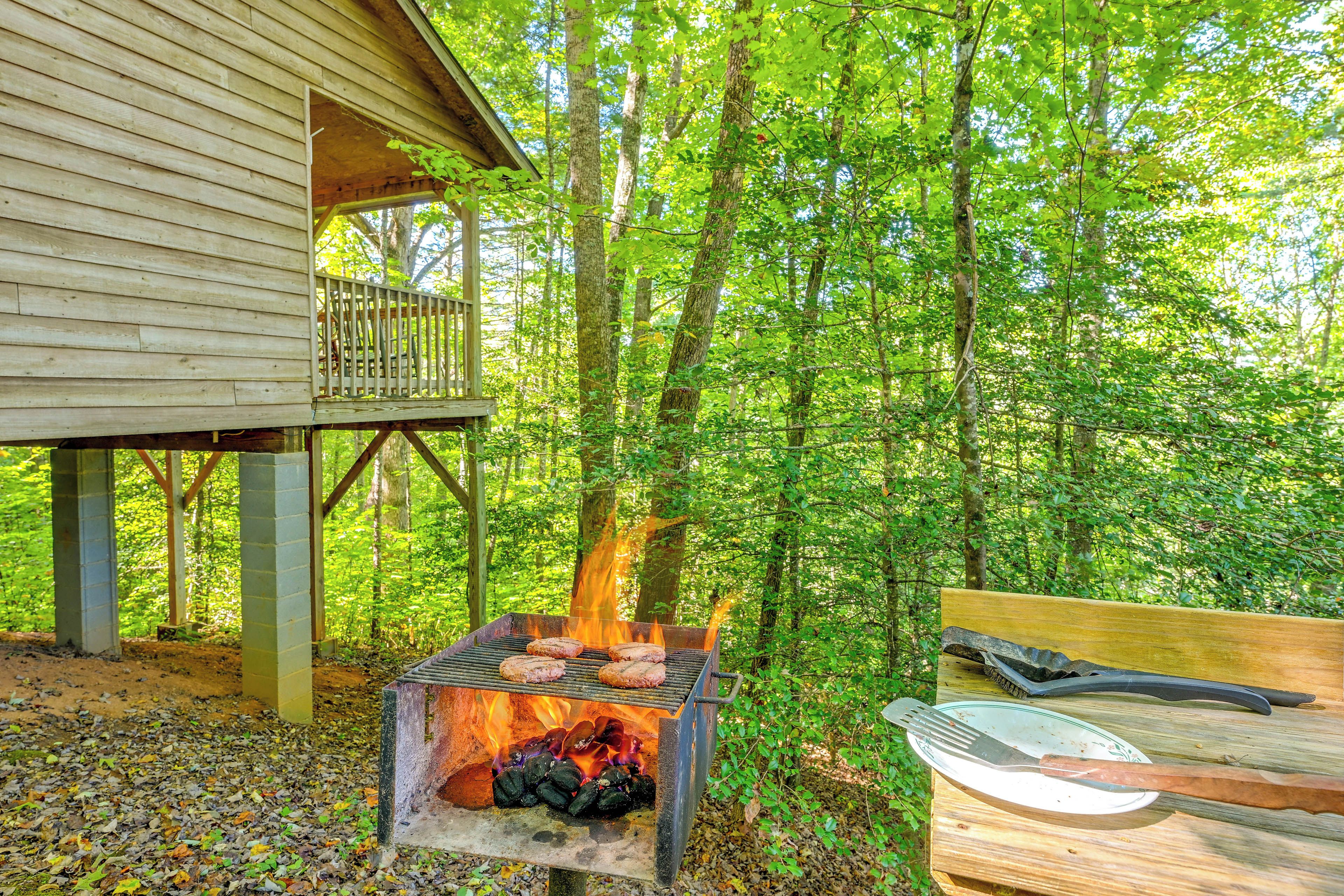 A wooden cabin with a grill and barbecue tools.