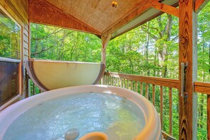 A hot tub on a wooden deck with a view of a forest. - Pet-friendly Smoky Mountain Cabin: Hunt & Fish! (Bryson City)