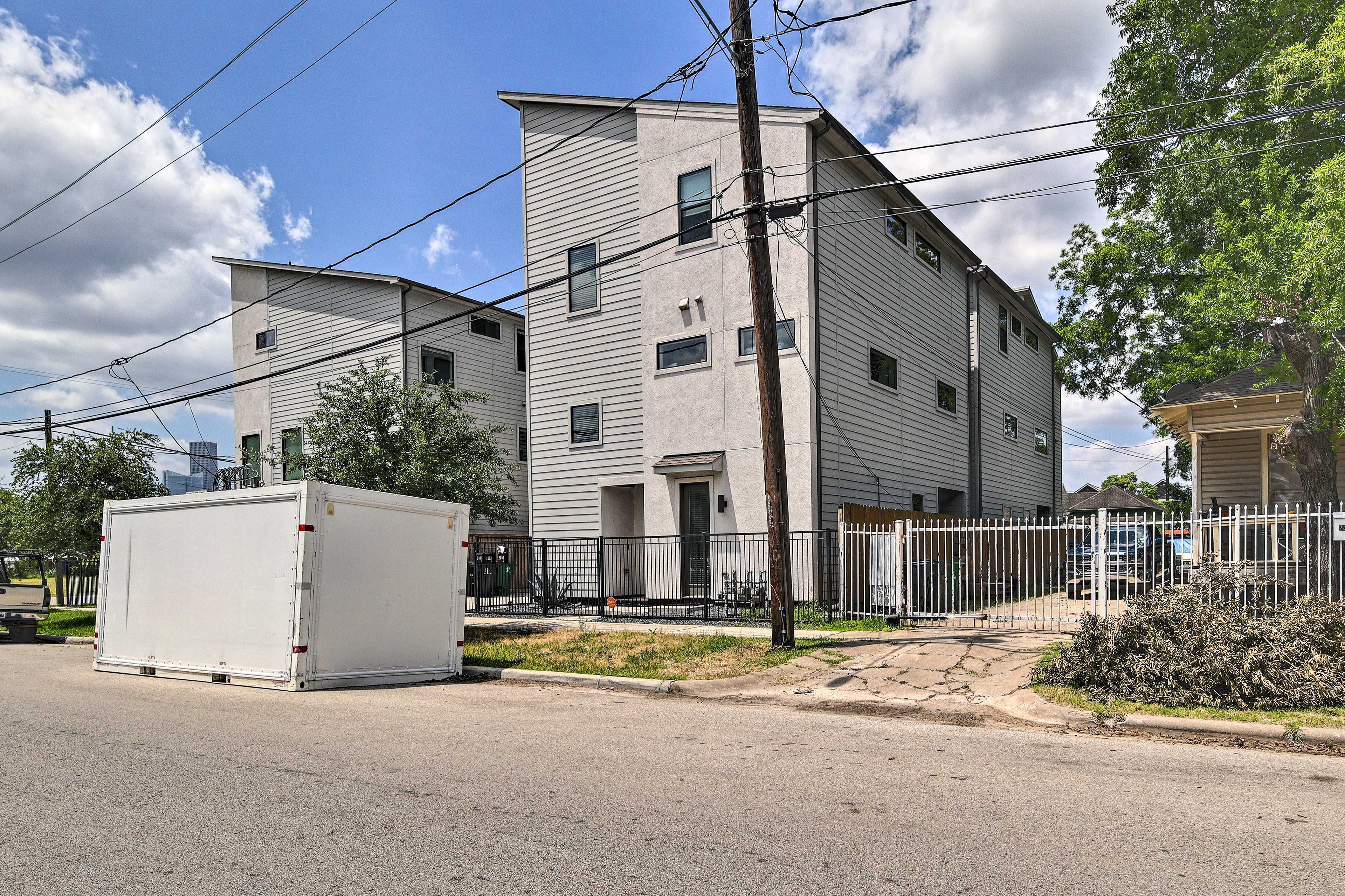 A two-story residential building with a flat roof and a white exterior.