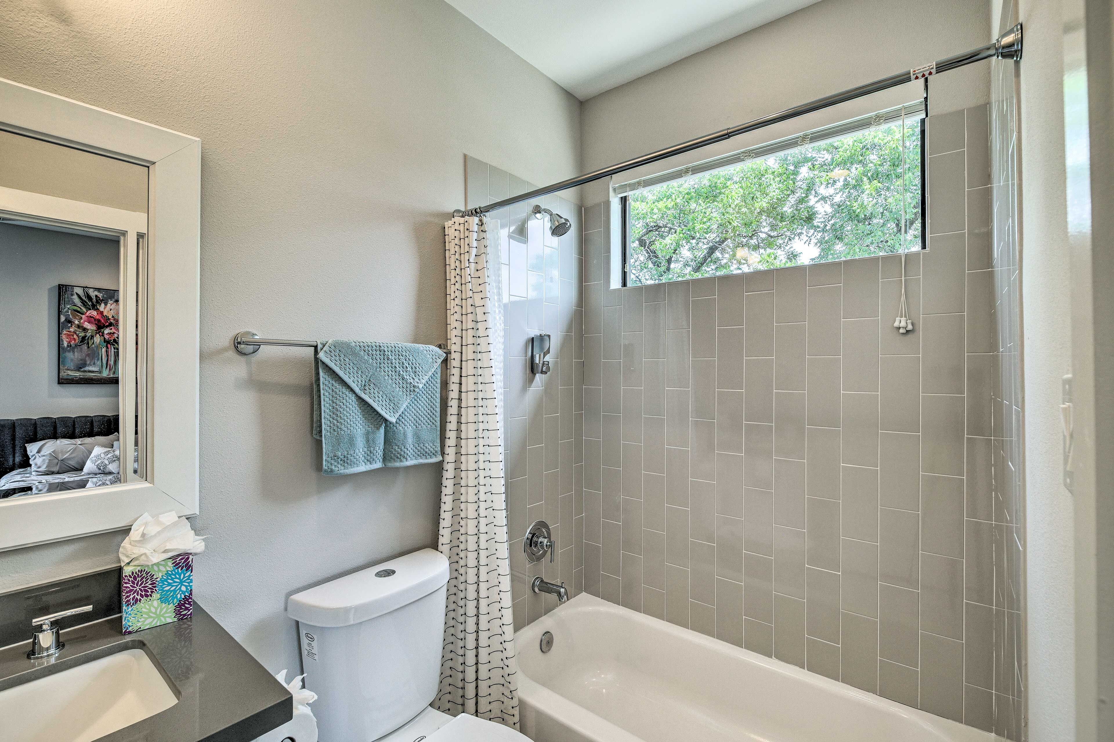 A bathroom with a shower, toilet, and sink.