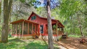 A red cabin with a porch, surrounded by trees. - Serene Cabin w/ Riverfront Views & Access! (Fayetteville)