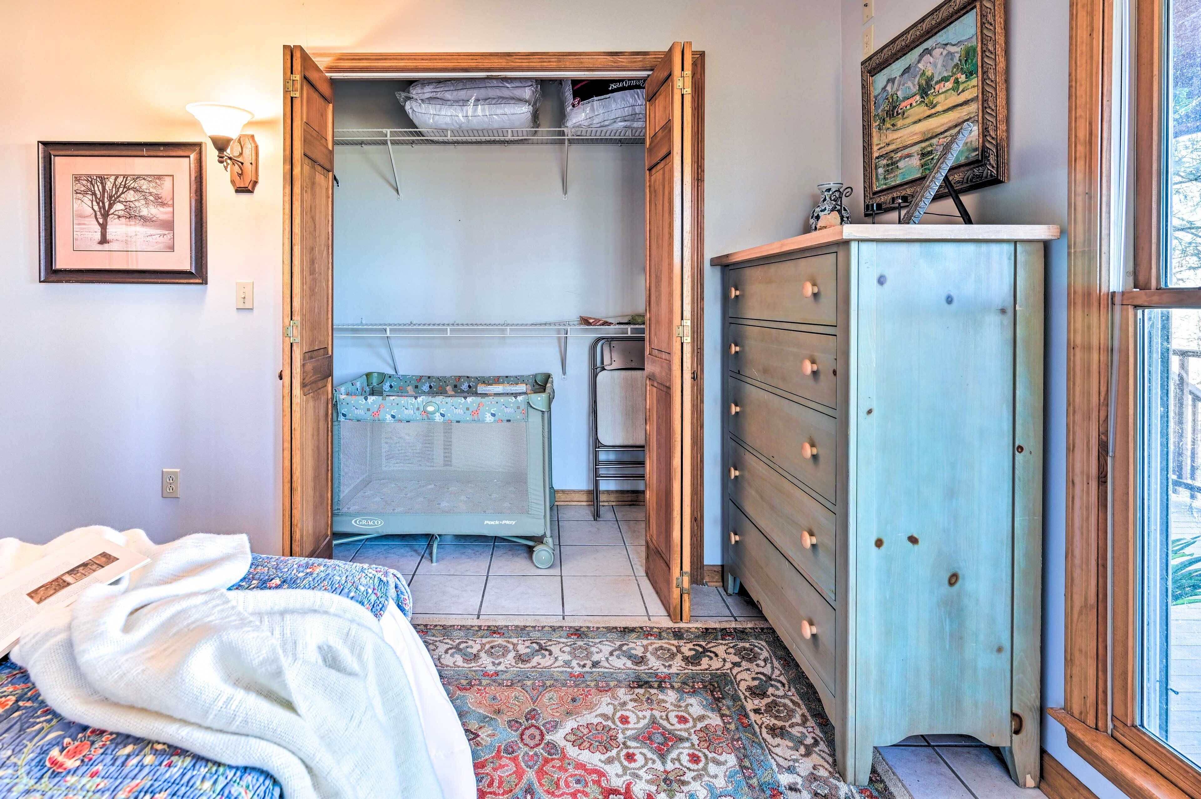 Un dormitorio con cama, cómoda, armario abierto y radiador.