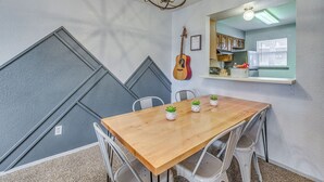 A dining area with a wooden table, chairs, and potted plants. - Hike, Golf & Explore: Ruidoso Retreat w/ Deck! (Ruidoso)