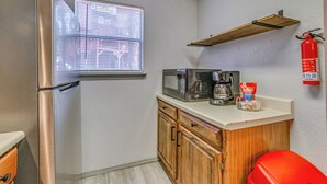 A compact kitchen with a stainless steel refrigerator, a microwave, and a coffee maker on the countertop. - Hike, Golf & Explore: Ruidoso Retreat w/ Deck! (Ruidoso)