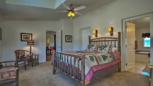 A bedroom with a large bed, a ceiling fan, and a bathroom visible through an open door. - 'the Fishing House' Buena Vista Home w/ Mtn Views! (Buena Vista)