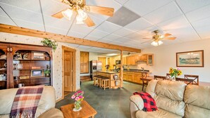 A spacious living room with leather sofas, a wooden coffee table, and a kitchen in the background. - Rustic Keosauqua Gem: Fire Pit & Lake Sugema Views (Keosauqua)