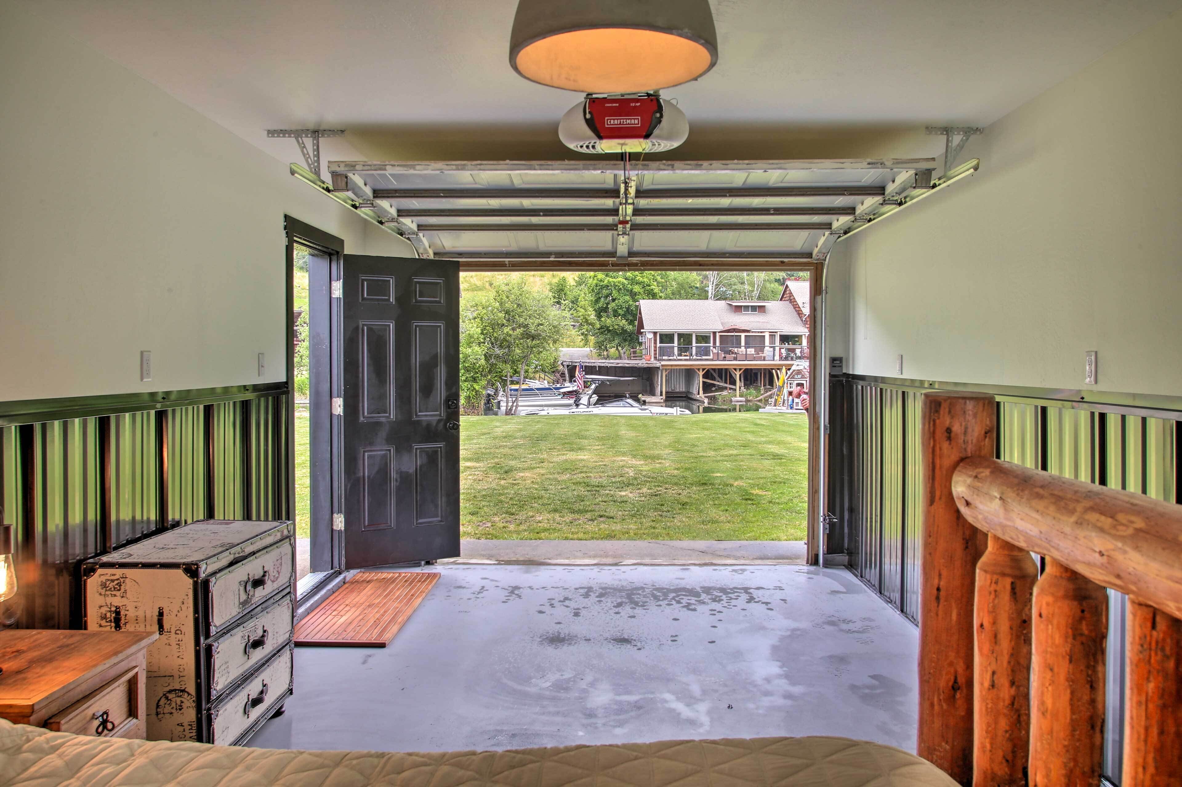 A garage entrance with a wooden door, a metal garage door, and a concrete floor.