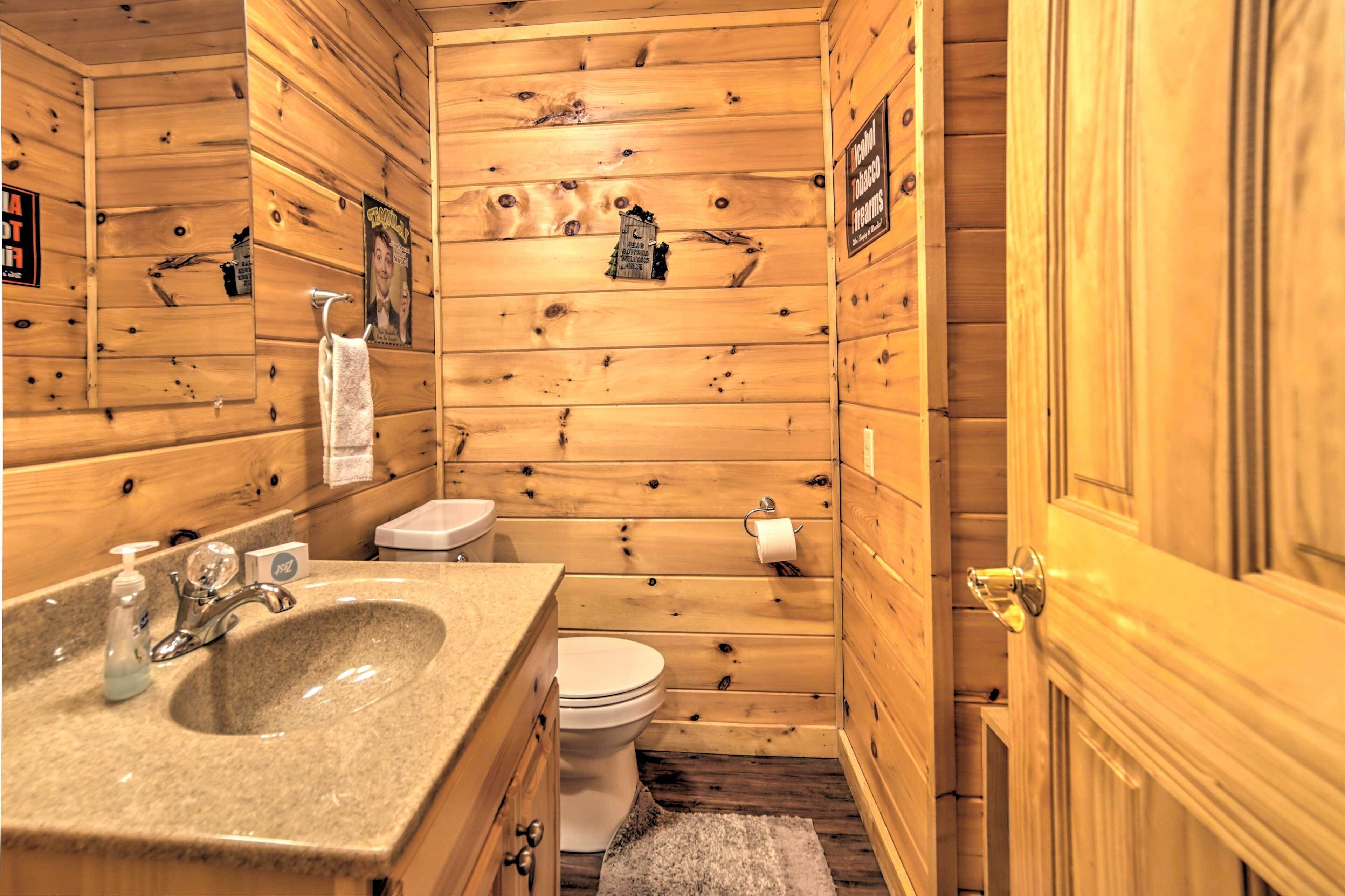 Ein Badezimmer im Holzblockhausstil mit einem Granittisch, einer Toilette und einer Holztür.