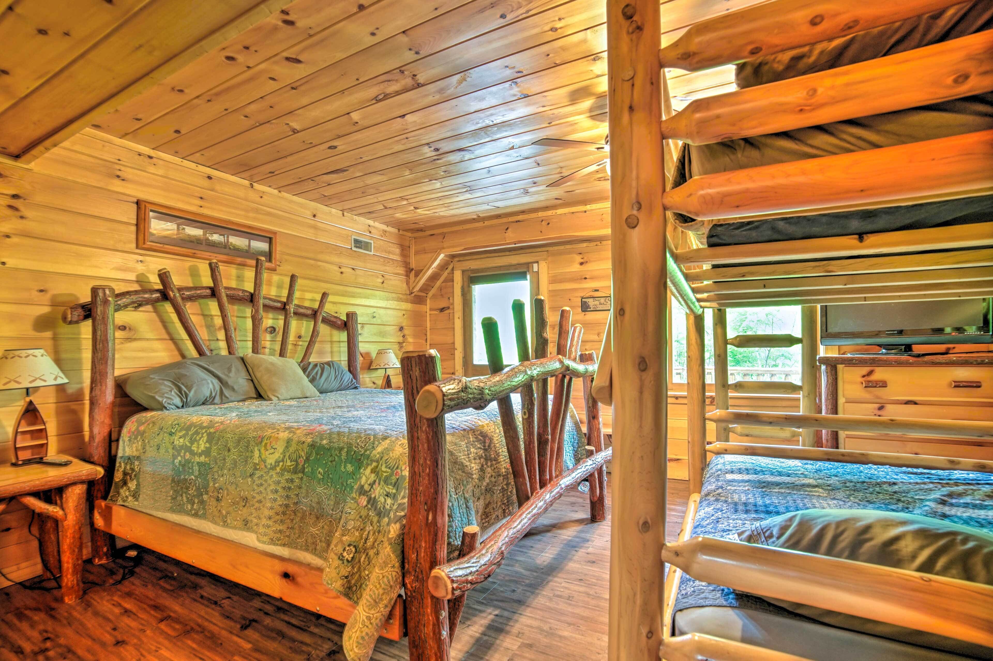 A wooden cabin room with a bed, a nightstand, and a window.
