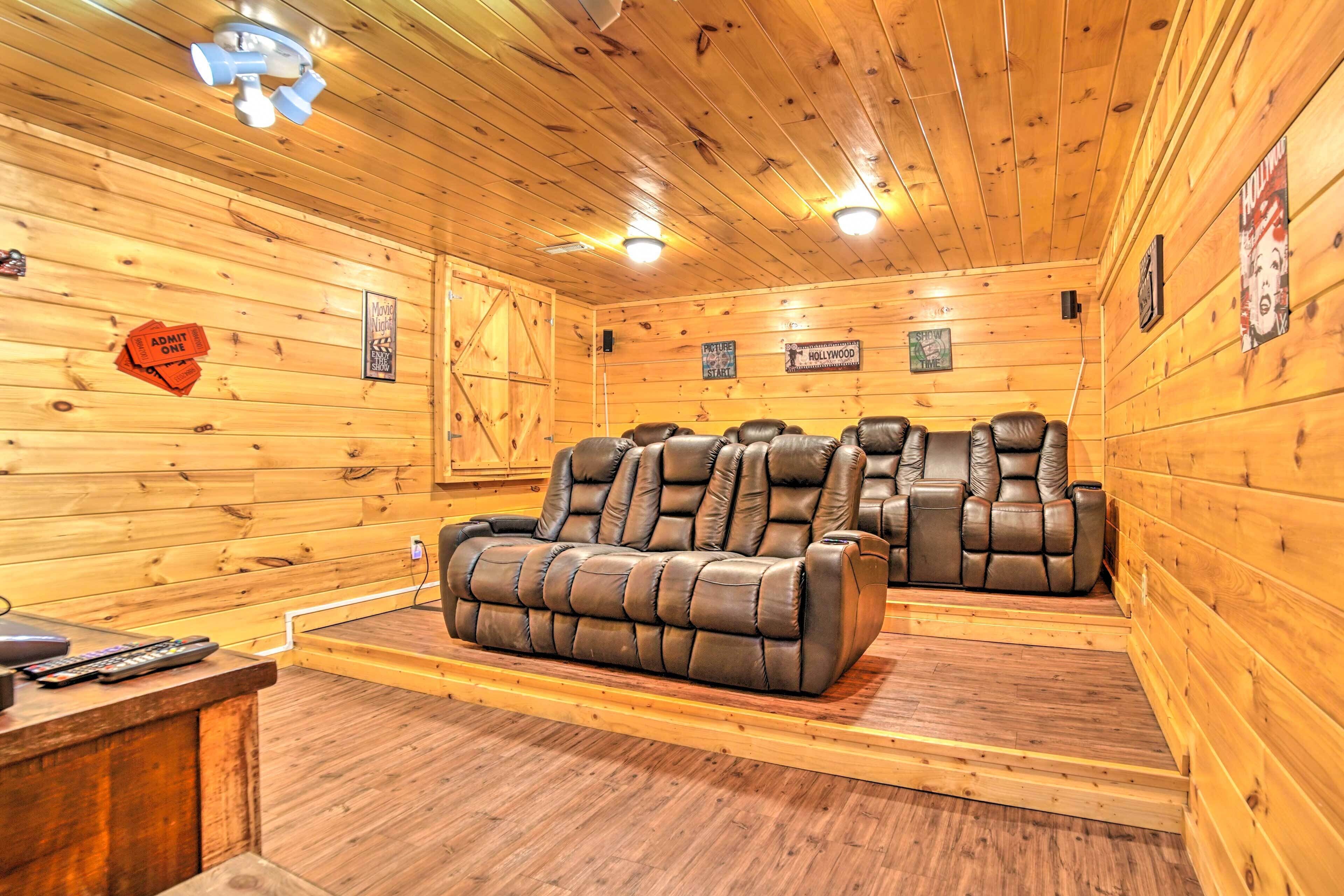 Ein Holzhütten-Interieur mit einer Couch und zwei Sesseln, einem Holzboden und einer Decke mit Lampen.