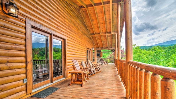 A wooden cabin with a covered porch, outdoor seating, and a scenic view. - Games, Theater & Views: Gatlinburg Gem Near Trails (Gatlinburg)