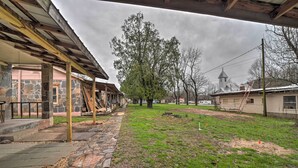 A courtyard with stone steps, a grassy area, and a building with a stone facade. - Unplugged Bryson City Cabin Near Downtown (Bryson City)