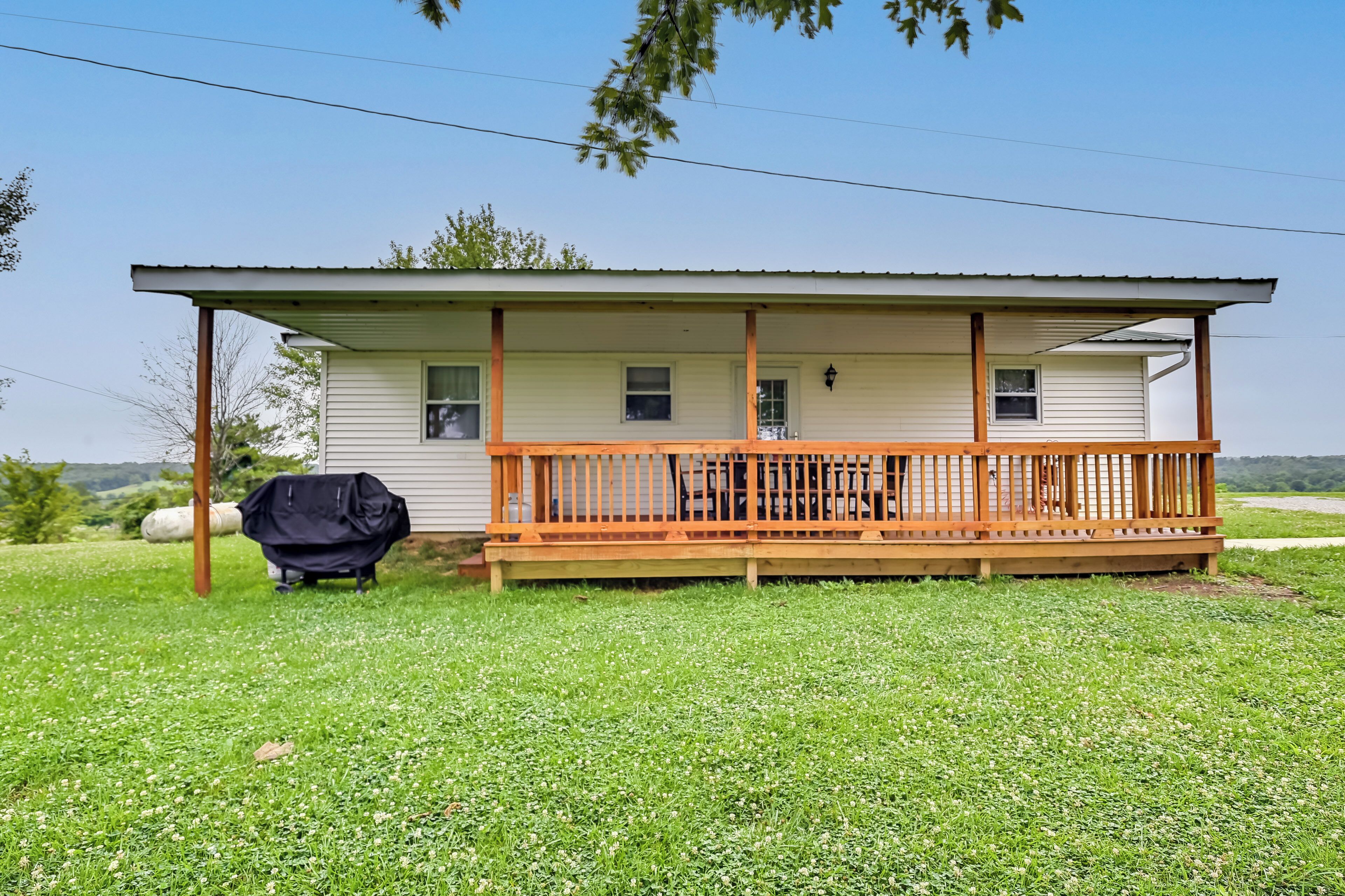 Einbungalow mit überdachter Veranda und Grill.