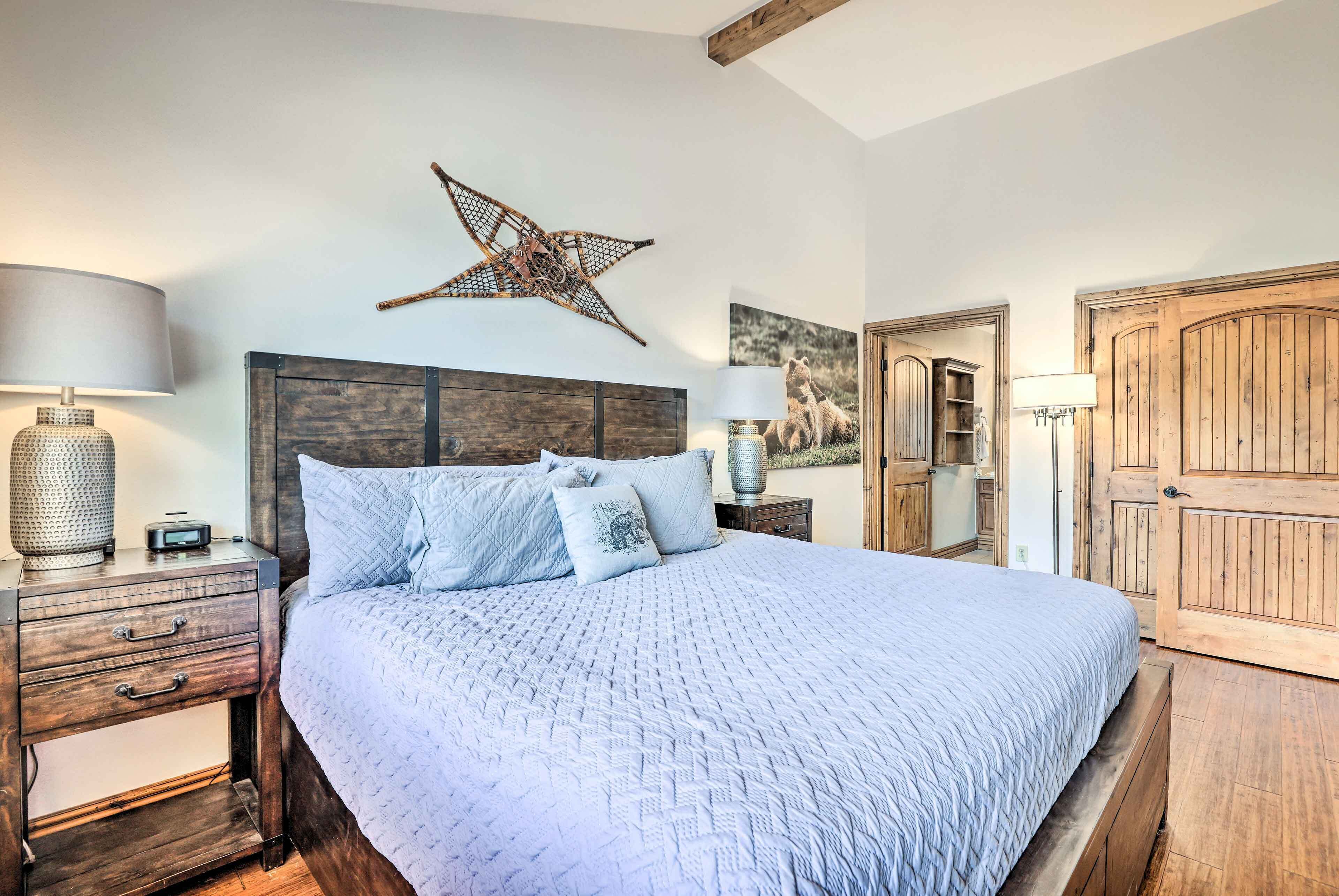 A bedroom with a large bed, wooden headboard, bedside tables, lamps, and a star decoration on the wall.