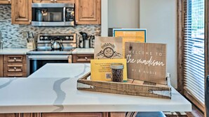A kitchen with wooden cabinets, a microwave, and a tray with a card and a jar. - Winter Park Condo w/ Mountain Views + Hot Tub (Winter Park)