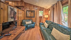 A wooden interior with a leather sofa, a television, and a painting of a horse. - 1 Mi to Raystown Lake: 'wyatt Earp Cabin' w/ Deck! (Huntingdon)
