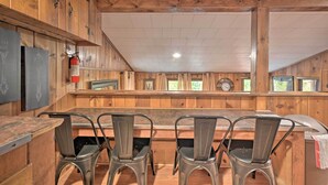 A wooden interior with a bar area, metal chairs, and a fire extinguisher. - 1 Mi to Raystown Lake: 'wyatt Earp Cabin' w/ Deck! (Huntingdon)