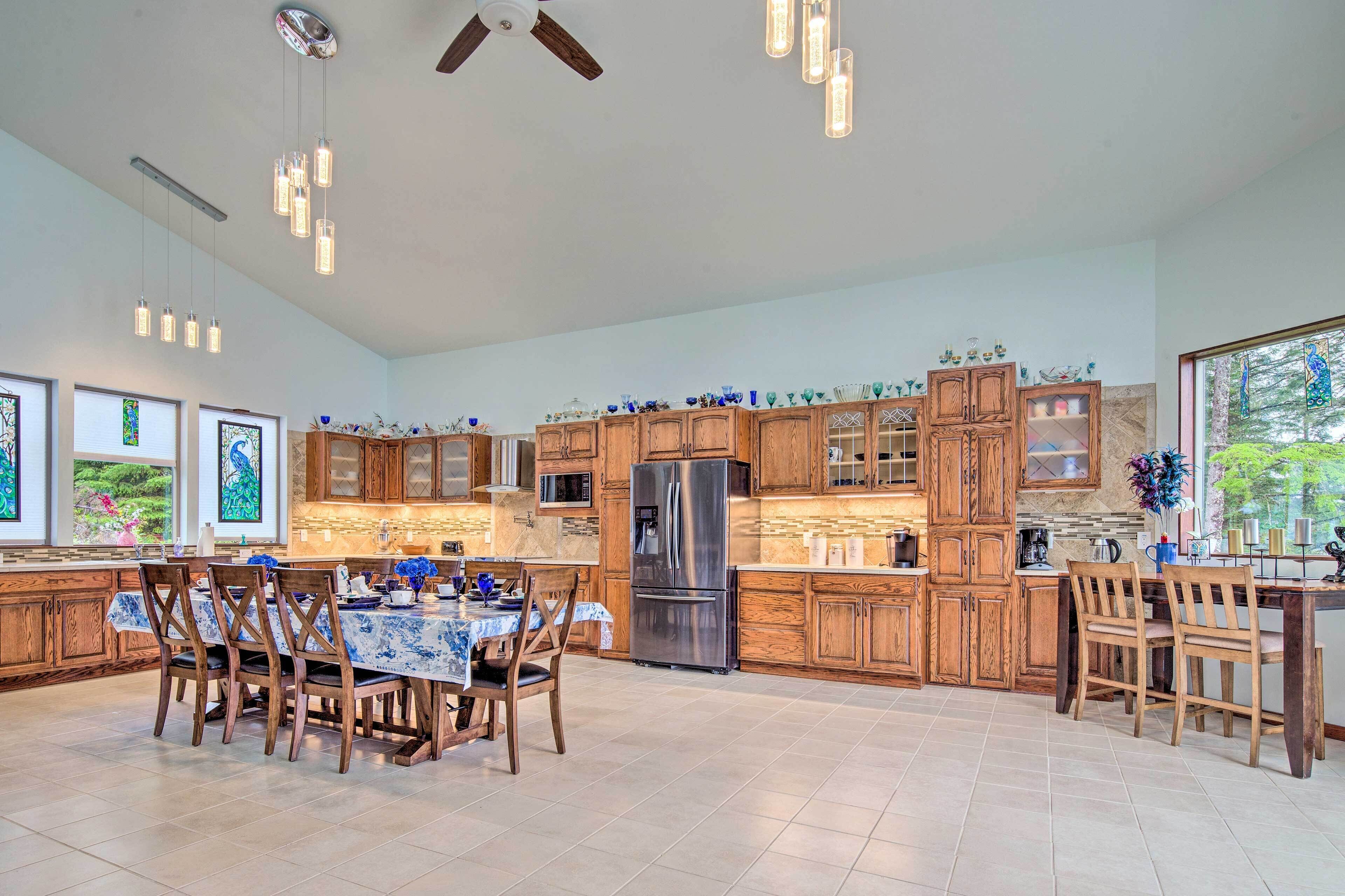 A spacious kitchen with wooden cabinets, a stainless steel refrigerator, and a dining area with a table and chairs.