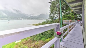 A wooden deck with a railing overlooking a body of water and mountains. - Waterfront House w/ Glacial Views - Near Downtown! (Juneau)
