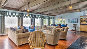 A spacious living room with a wooden ceiling, large windows, and a view of the outdoors. - Waterfront House w/ Glacial Views - Near Downtown! (Juneau)