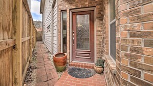 A brick house with a wooden fence, a front door, and a large planter. - 2,500 Sq Ft Townhome - Walk to Central River Oaks! (Houston)