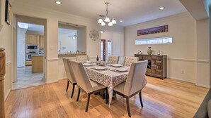 A dining room with a table set for six, wooden flooring, and a chandelier. - 2,500 Sq Ft Townhome - Walk to Central River Oaks! (Houston)
