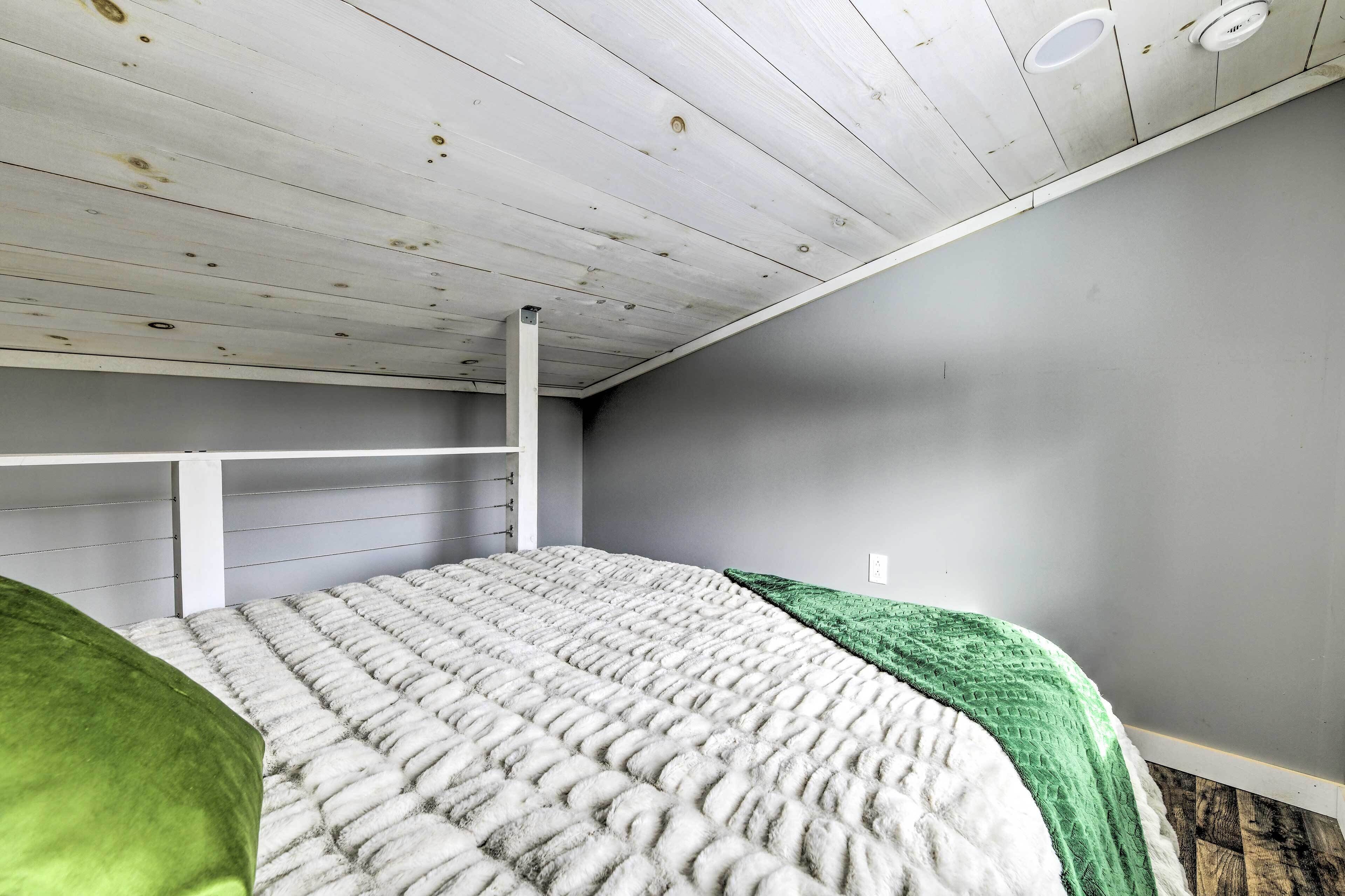 Un dormitorio con literas, techo blanco y pared gris.