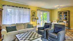 A living room with a sofa, armchairs, a coffee table, and a cabinet.
