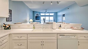 Una cocina moderna con armarios blancos, un lavamanos doble y un ventilador de techo.