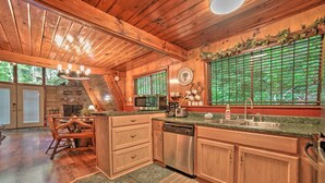 A kitchen with wooden cabinets, a stainless steel dishwasher, and a granite countertop. - A-frame Gatlinburg Cabin w/ Deck & Private Hot Tub (Gatlinburg)