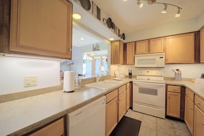 A kitchen with wooden cabinets, a microwave, an oven, and a sink. - All-season Base! Unit w/ Balcony in Beech Mountain (Banner Elk)
