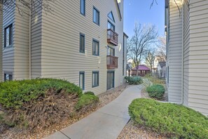 A residential building with a narrow pathway, a wooden deck, and a small garden area.