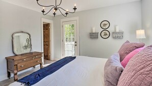 A bedroom with a large bed, a wooden dresser, a mirror, and a chandelier. - 'blackberry Roost' Home ~ 4 Mi to Downtown Salado (Salado)