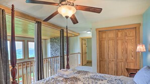 Une chambre avec un grand lit, une armoire en bois et un balcon avec des rideaux.