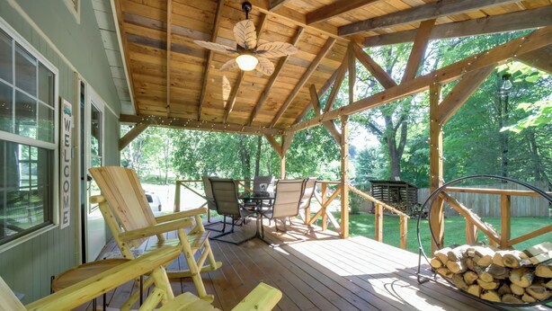 A wooden deck with outdoor furniture, a ceiling fan, and a stack of firewood. - Charming Waynesville Cottage < 2 Mi to Main St (Waynesville)