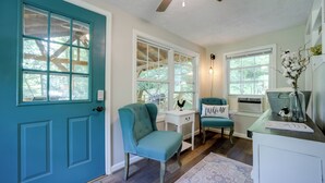 A teal-themed room with a wooden ceiling fan, a white desk, teal chairs, and a white door with windows. - Charming Waynesville Cottage < 2 Mi to Main St (Waynesville)
